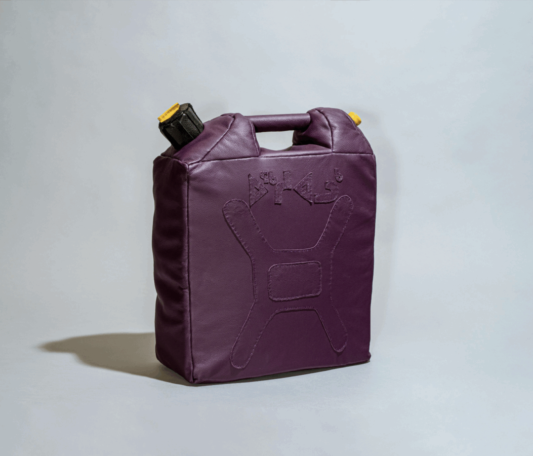 A soft, rectangular bag shaped like a jerry can, made of deep purple leather with stitched details resembling a fuel container. The top has a short handle and a black cap with a yellow accent.